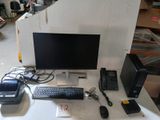 un bureau sur lequel se trouvent un écran, un clavier, une souris et d'autres appareils électroniques