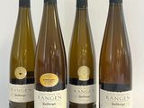 quatre bouteilles de vin sont alignées sur une table