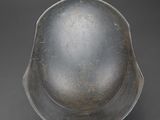 an old metal bowl sitting on top of a black surface