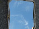 un miroir posé par terre, avec le ciel en arrière-plan