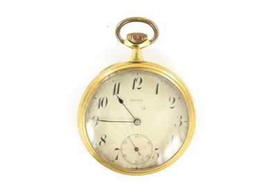 une montre de poche en or sur une surface blanche avec un fond blanc