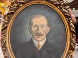 un homme tenant un tableau représentant un homme en costume