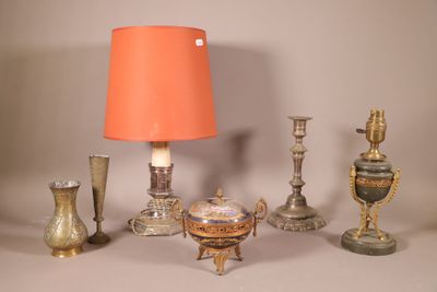 une table sur laquelle se trouvent une lampe, des vases et d'autres objets