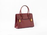 un sac à main rouge posé sur une surface blanche
