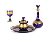 un service en verre bleu et or, composé d'une tasse et d'une soucoupe dorées