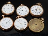 quatre montres de poche différentes posées sur une surface noire