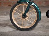 a close up of a green motorcycle parked on a concrete floor