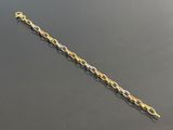 a close up of a gold chain bracelet on a black surface