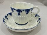 une tasse et une soucoupe bleues et blanches posées sur une table