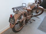 a brown motorcycle parked in a room with a rug