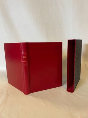 two red books sitting next to each other on a white surface