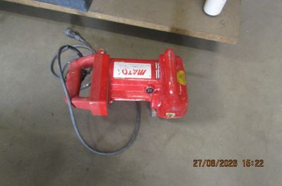 un ventilateur rouge posé par terre à côté d'une table