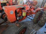 a red tractor that is parked in a garage