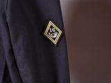 a close up of a black jacket with a gold badge on it