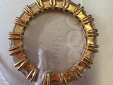 an image of a gold ring on a white surface with a thread