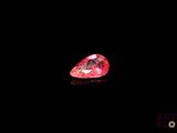 a close up of a pink diamond on a black surface