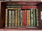 de nombreux vieux livres dans une boîte rouge posée par terre