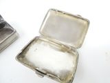two silver boxes sitting next to each other on a table