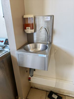 un évier dans un coin de la cuisine, avec un téléphone à l'intérieur