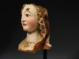 a carved head of a woman on a black stand