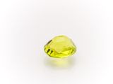 a close up of a yellow diamond on a white surface