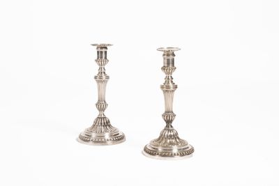 une paire de chandeliers en argent sur fond blanc