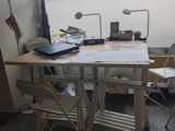 une table avec des chaises et un ordinateur portable posé dessus, dans une pièce
