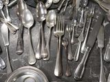 a lot of silver spoons and silverware on the table