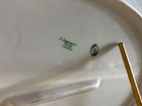 a close up of a white plate with a gold handle