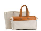 beige and white canvas tote bag with tan leather handles