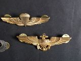three military badges are shown on a black surface