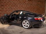 a black sports car parked in front of a brick wall