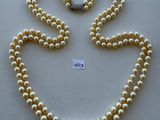un collier de perles blanches avec un fermoir en forme de cœur