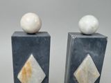 pair of marble salt and pepper shakers with a white ball on top