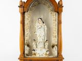 statue of the virgin of guadalupe in a wooden frame on a white background