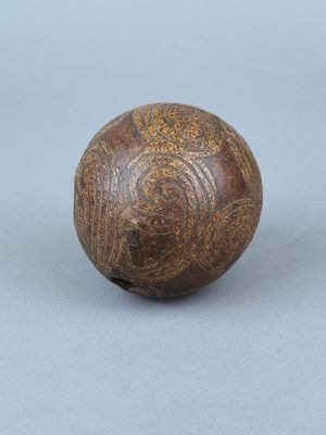 une vieille boule en bois posée sur une surface grise