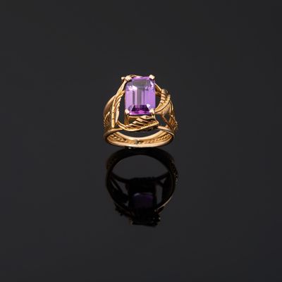 a gold ring with an amethorate stone in the center