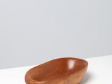 a wooden bowl sitting on top of a white table