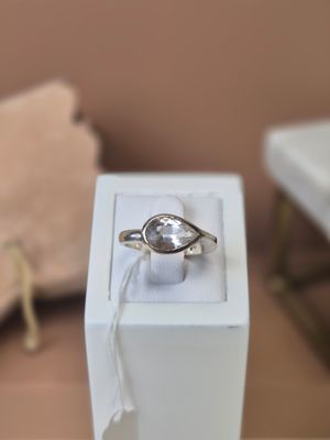 une boîte blanche posée sur une table, contenant un anneau à l'intérieur