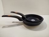 a black pan with a handle on a white table