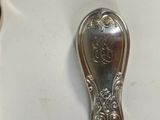a silver spoon and spoon rest on a white table