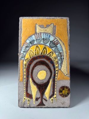 carreau de céramique jaune et marron sur lequel est représenté le visage d'une femme
