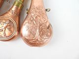 three copper spoons sitting next to each other on a table