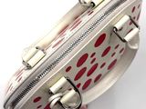 a white purse with red spots on it on a white surface