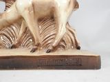 a statue of a deer that is standing on a rock