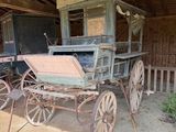 une calèche dans une grange au toit en bois