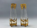 paire de vases anciens en or et cristal, posés sur un socle, sur fond gris