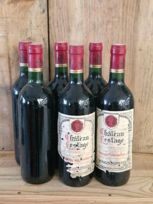 four bottles of wine are lined up on a wooden shelf