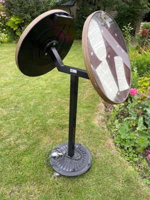 an image of a mirror on a stand in a garden