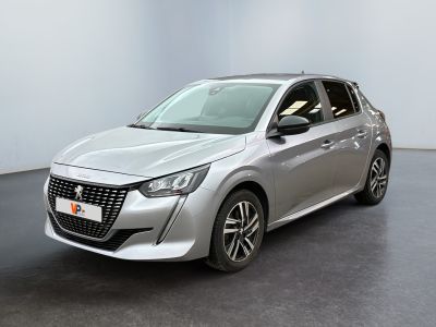 La voiture argentée est garée dans une pièce blanche au sol noir.